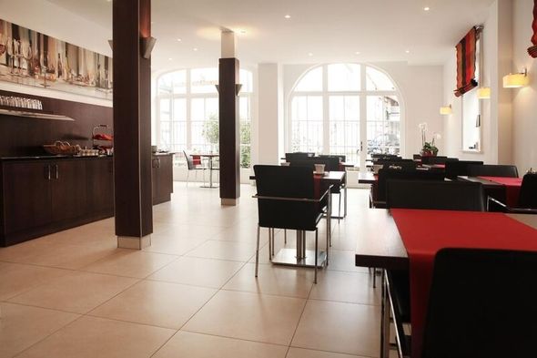 Eleganter Essbereich eines Hotels mit braunen Bodenfliesen und weißen Wänden